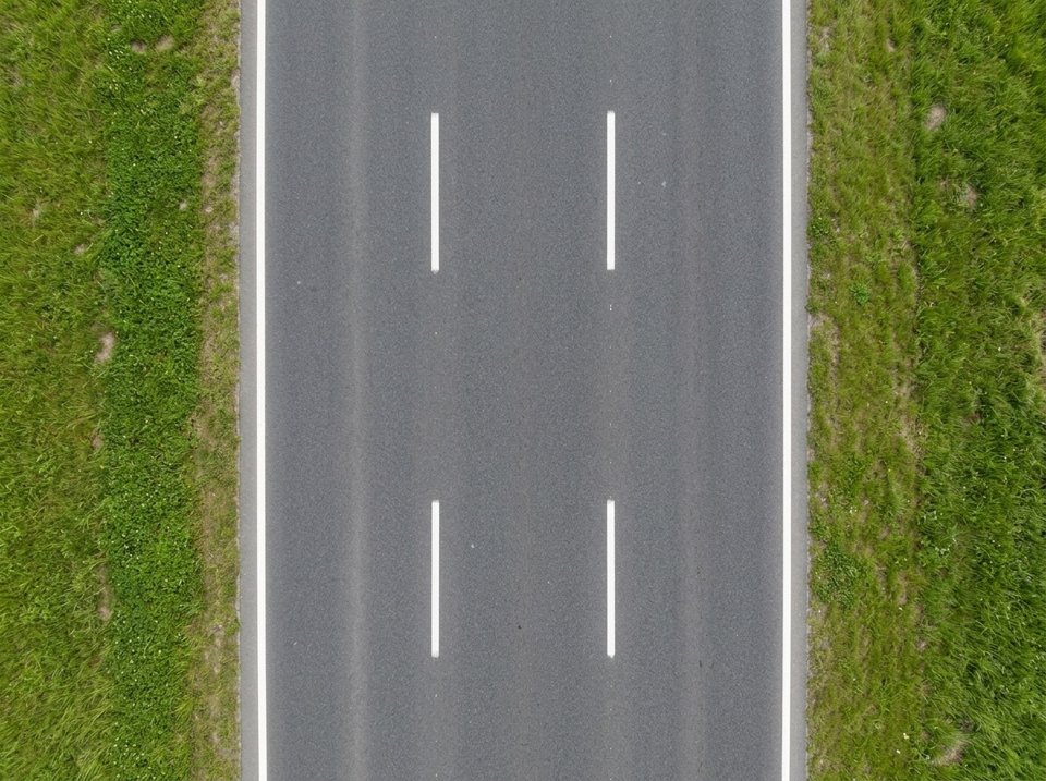 Unterbrochene weiße Linien teilen diese Fahrbahn in drei Fahrstreifen.